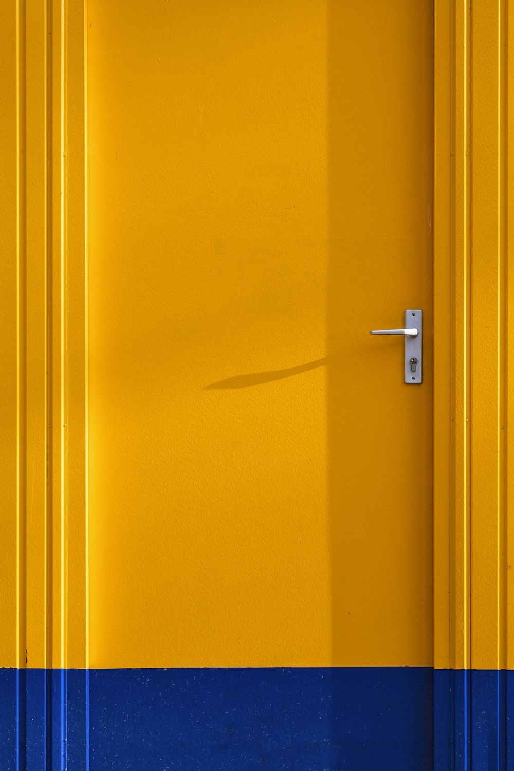 yellow wooden door with silver door lever