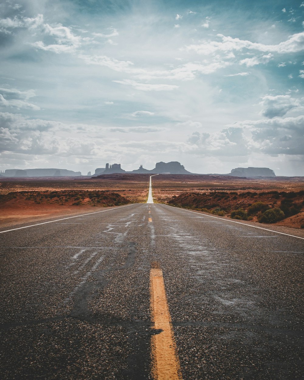 gray asphalt road under cloudy sky during daytime