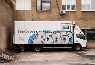 A large truck loaded with film equipment parked near a movie set.