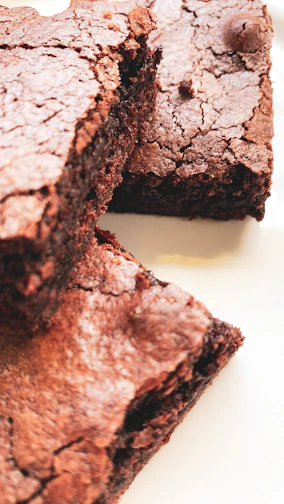 Close-up of a freshly baked chocolate brownie with a gooey center on a rustic wooden board