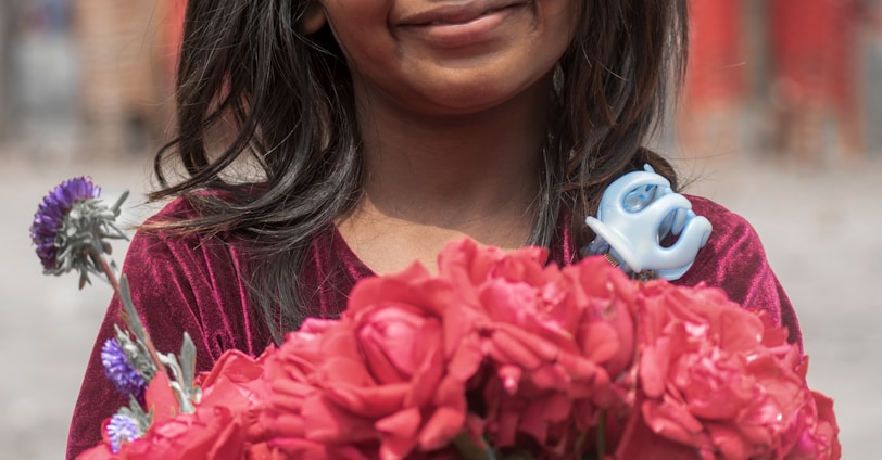 woman in red floral dress holding pink flower bouquet