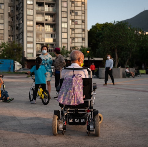 woman in pink shirt riding on black and red wheel chair