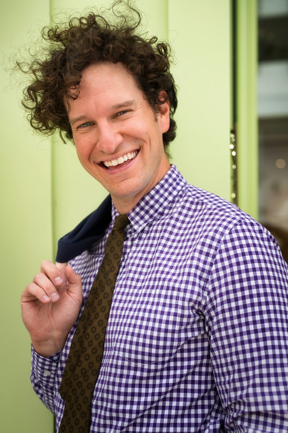 Hombre sonriente con camisa de vestir a cuadros azul y blanco