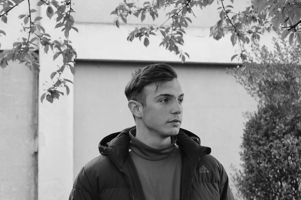 man in black jacket standing near wall