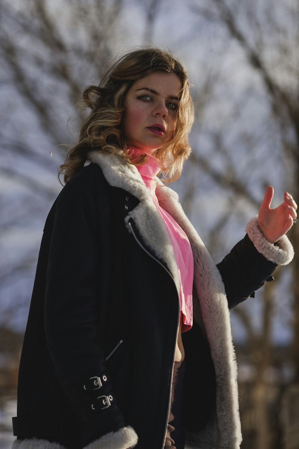 woman in black and white coat standing on snow covered ground during daytime