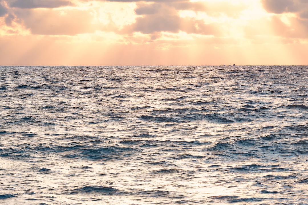 body of water under cloudy sky during daytime