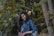woman in blue denim jacket standing beside tree