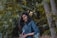woman in blue denim jacket standing beside tree