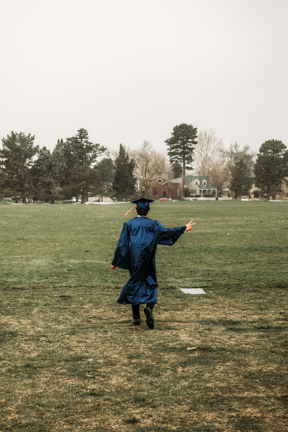 man in blue long sleeve shirt and black pants standing on green grass field during daytime