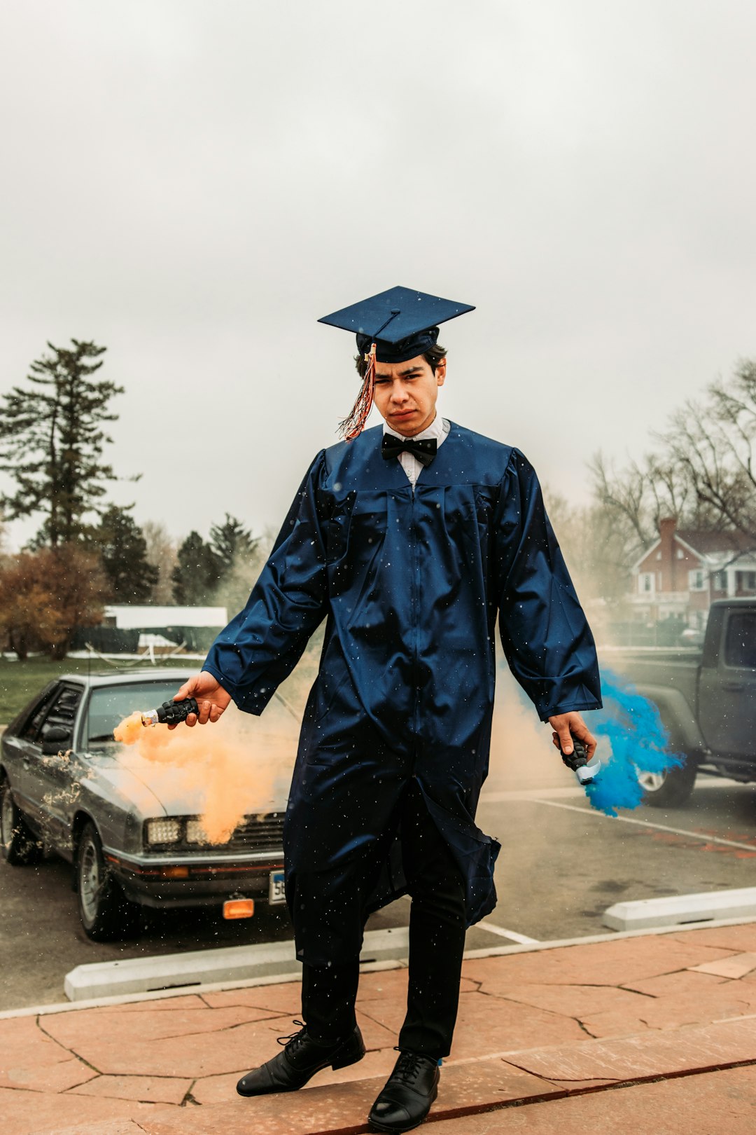 man in blue academic dress standing near car