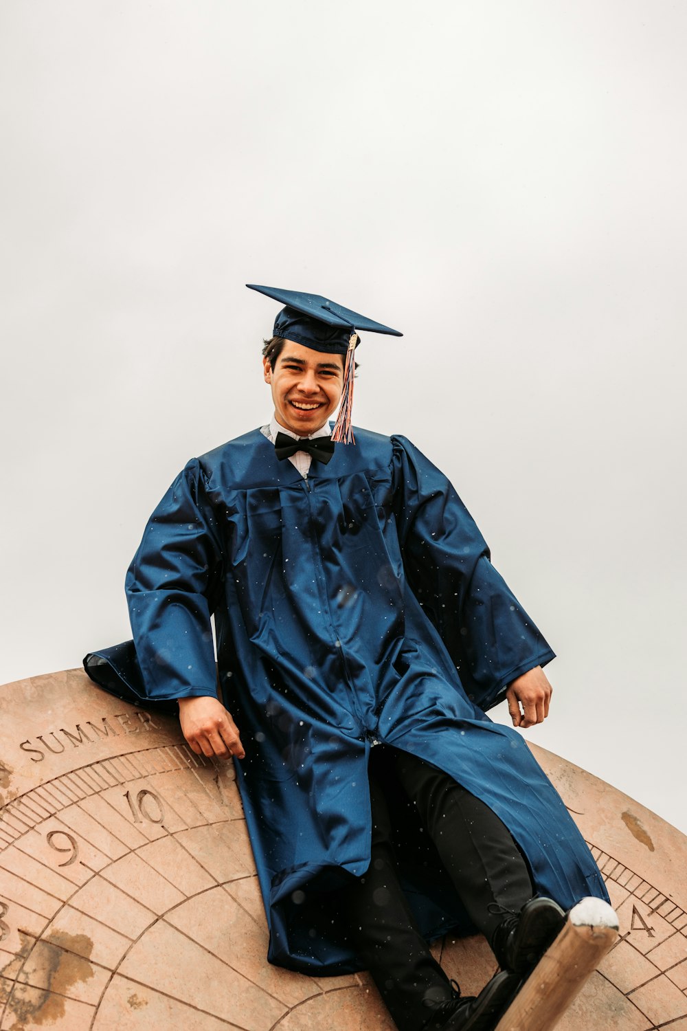 man in blue academic dress and black academic hat
