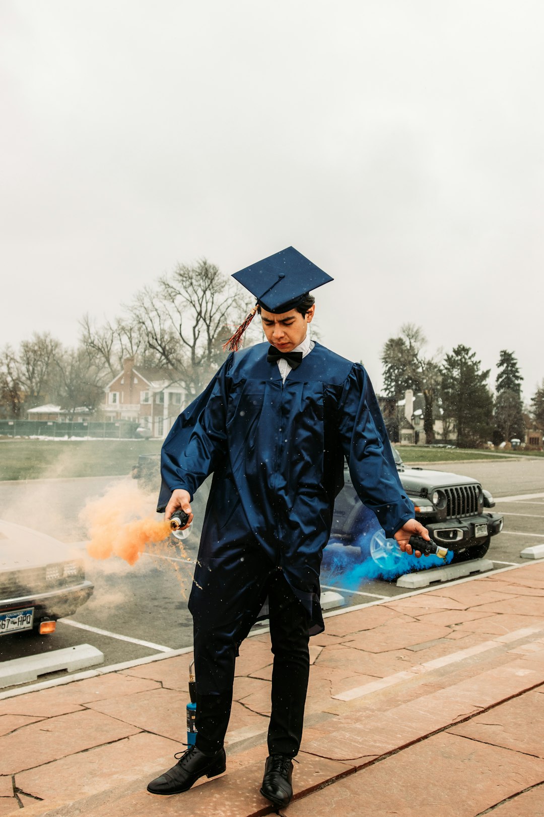 man in black academic gown standing on road during daytime