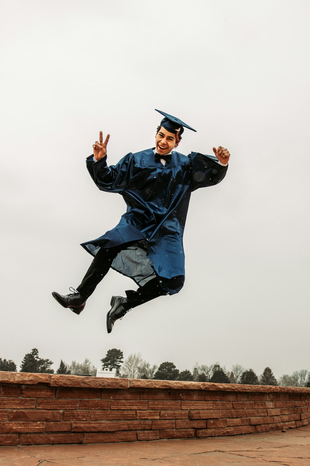 man in black academic dress and black mortar board