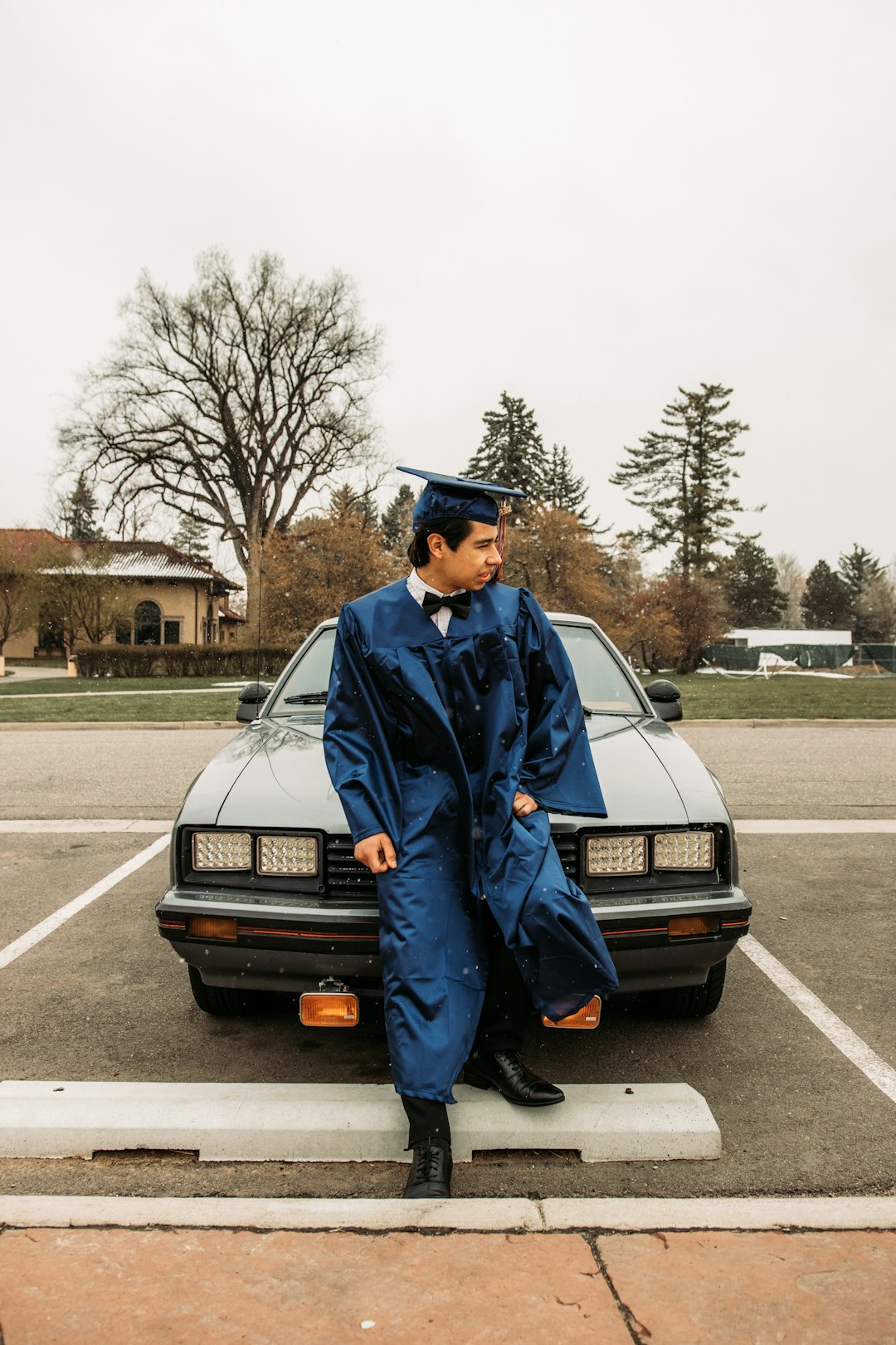 man in blue long sleeve shirt standing beside black car during daytime