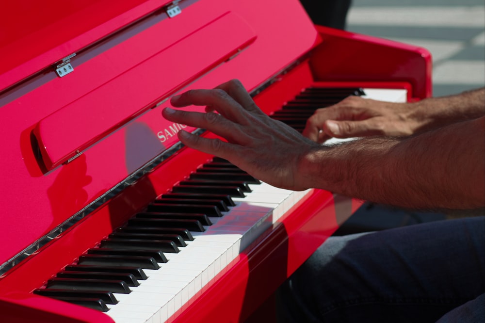 person playing red and white piano