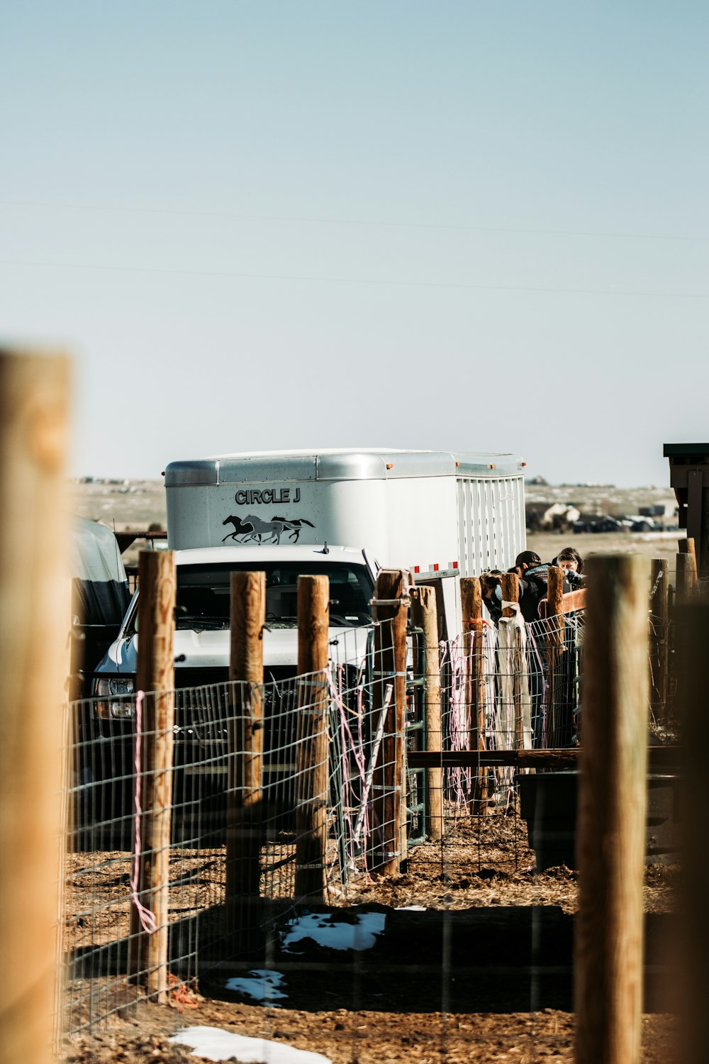 white and gray container van on brown wooden fence during daytime