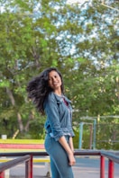 woman in blue denim jacket standing near green trees during daytime