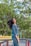 woman in blue denim jacket standing near green trees during daytime