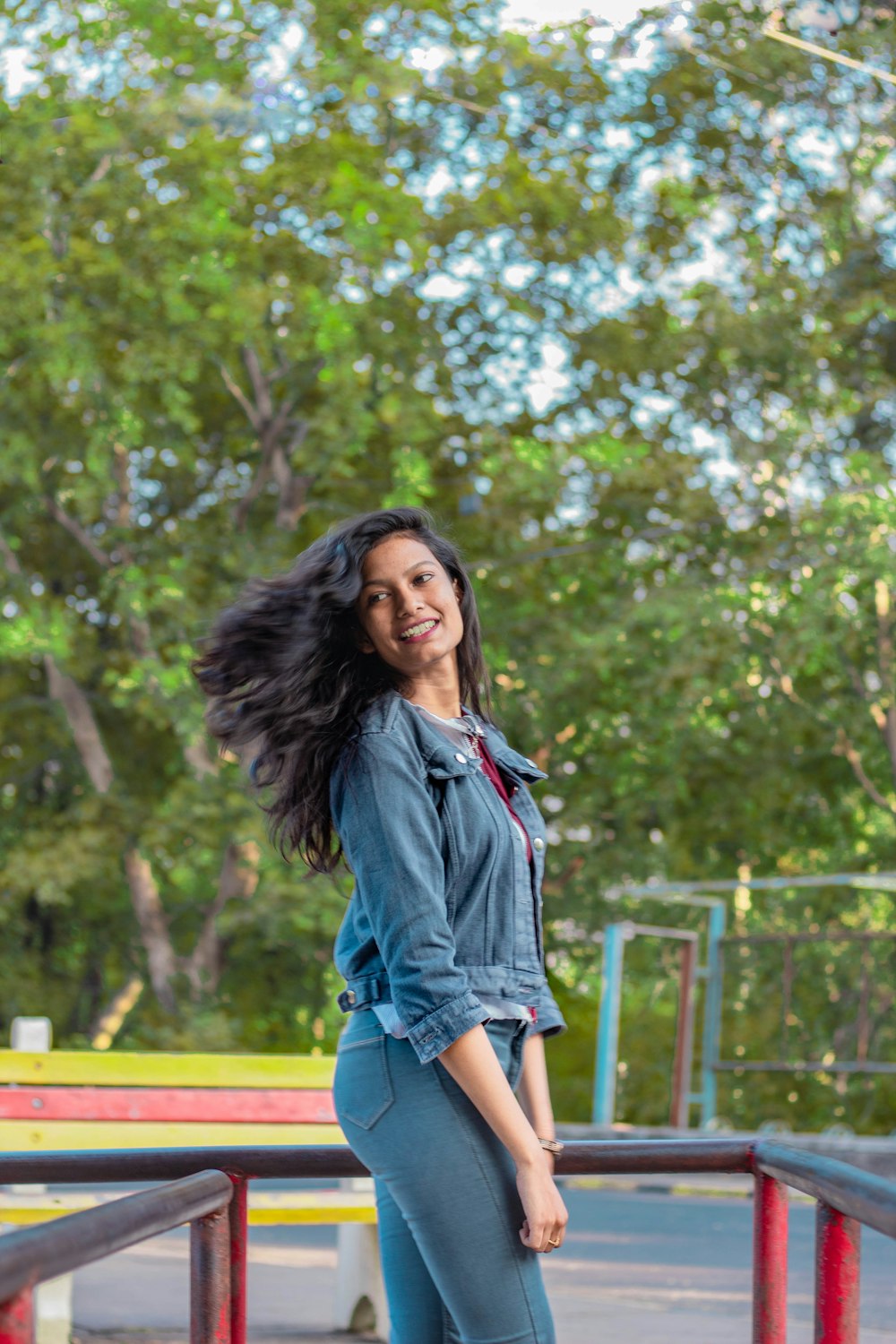 woman in blue denim jacket standing near green trees during daytime