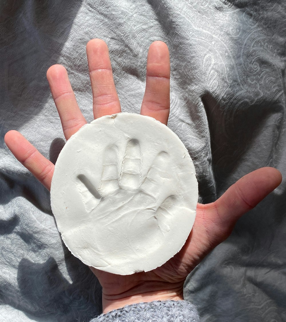 person holding white round ornament