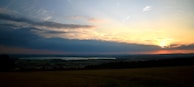 A tranquil sunset over a vast expanse of farmland.