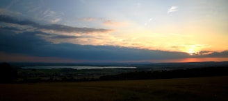A tranquil sunset over a vast expanse of farmland.