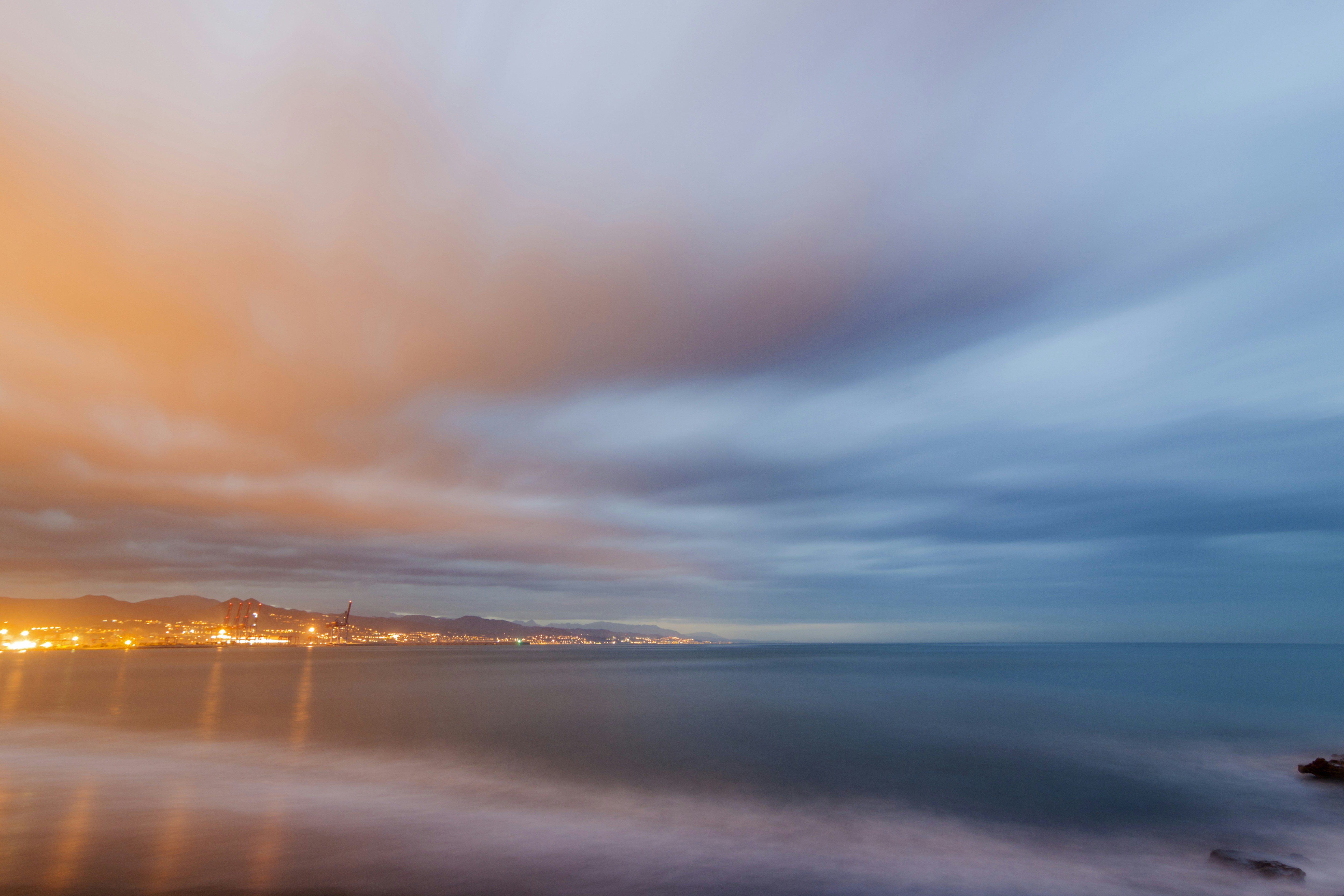 body of water under cloudy sky during sunset