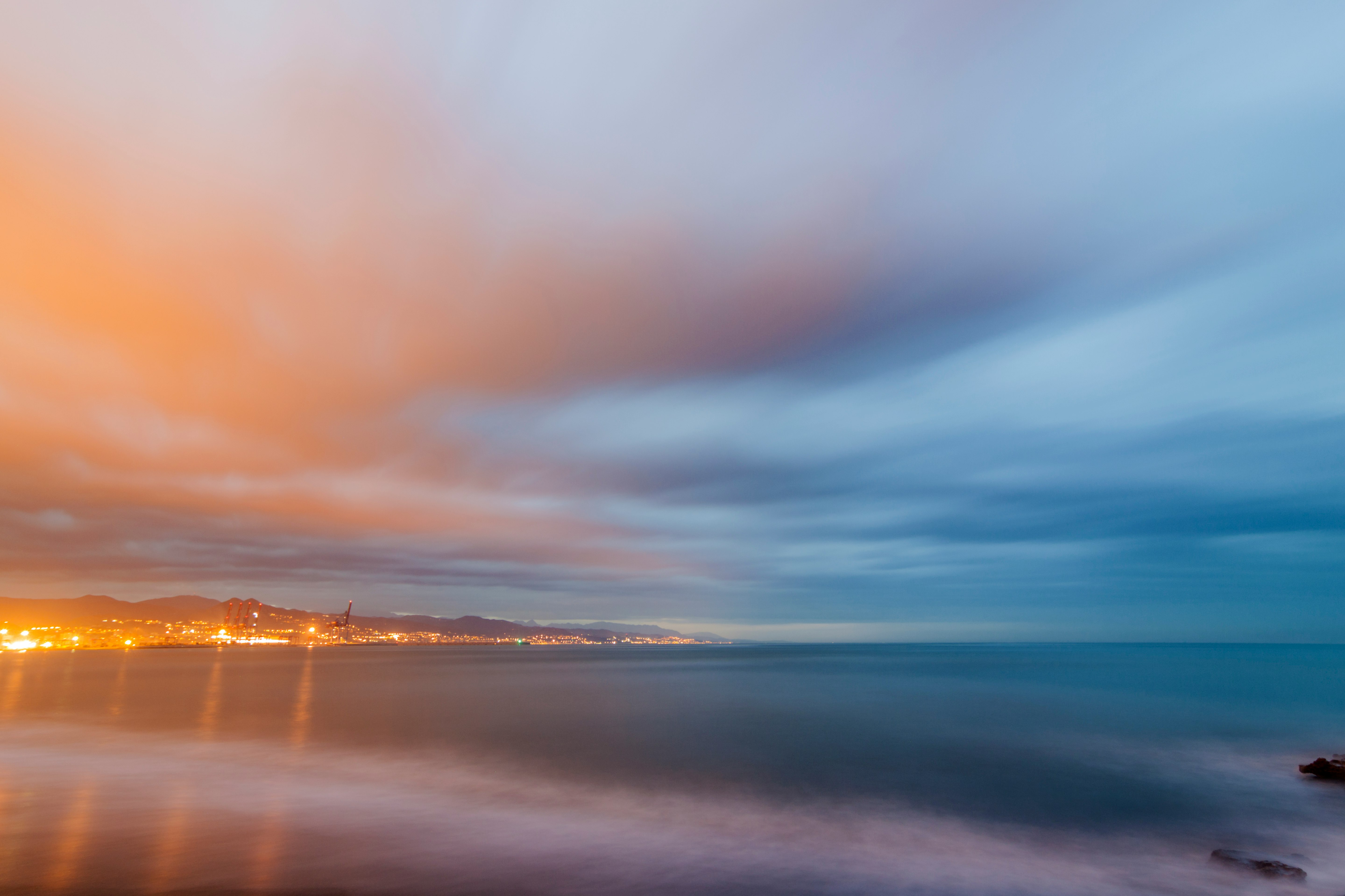 body of water under cloudy sky during sunset