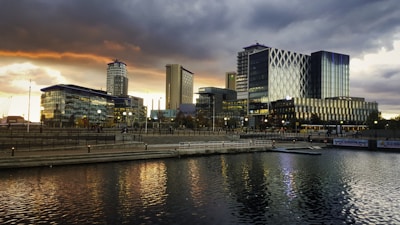 city skyline across body of water during night time