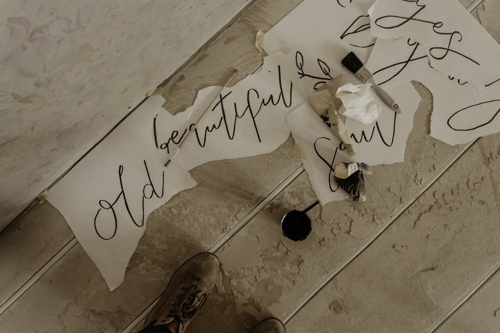 person in brown leather shoes standing on white floor tiles