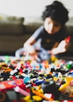 boy in gray crew neck t-shirt playing lego blocks