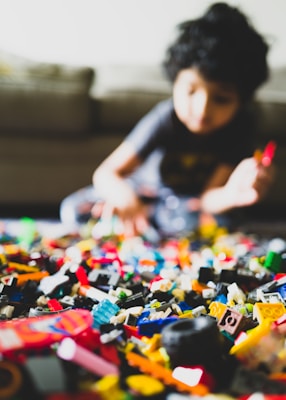 boy in gray crew neck t-shirt playing lego blocks