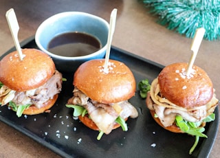 burger with lettuce and tomato on black plate