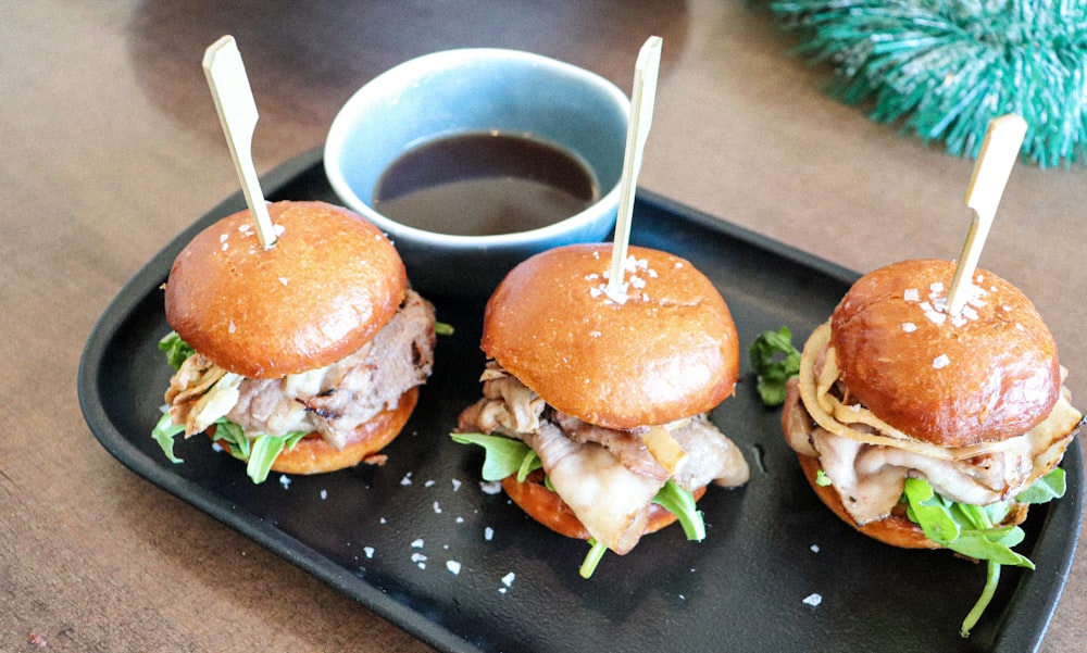 burger with lettuce and tomato on black plate