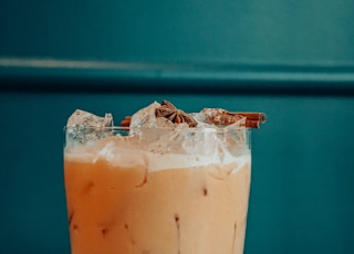 clear drinking glass with brown liquid and ice