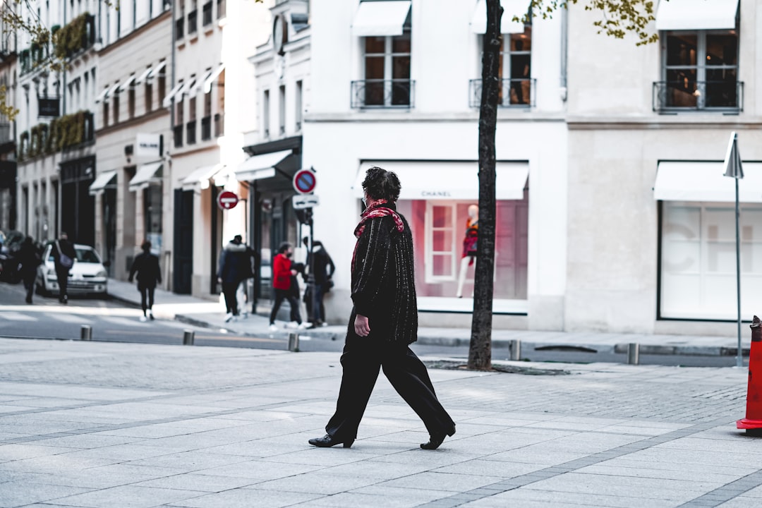 man in black and red coat walking on street during daytime