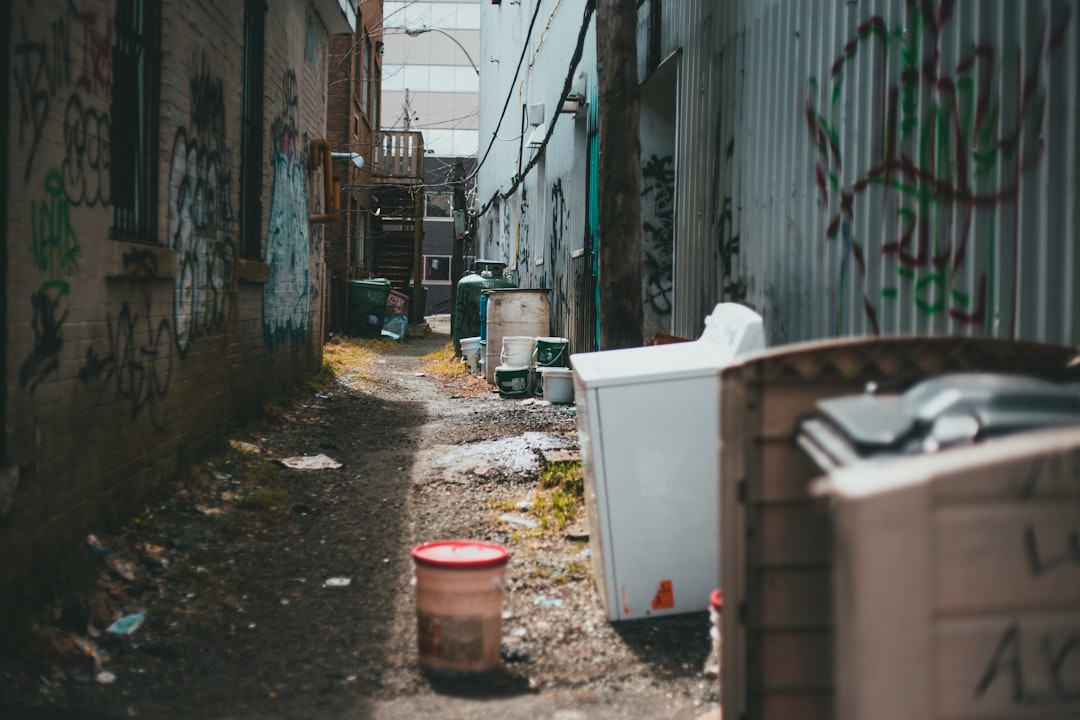 white and red plastic bucket beside gray wall