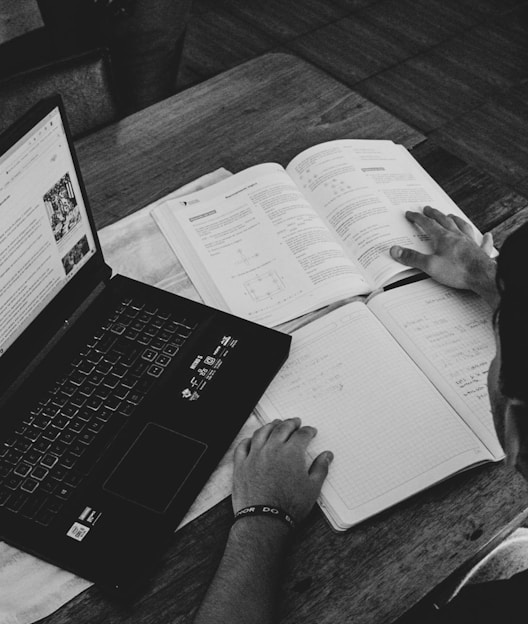 grayscale photo of person holding book