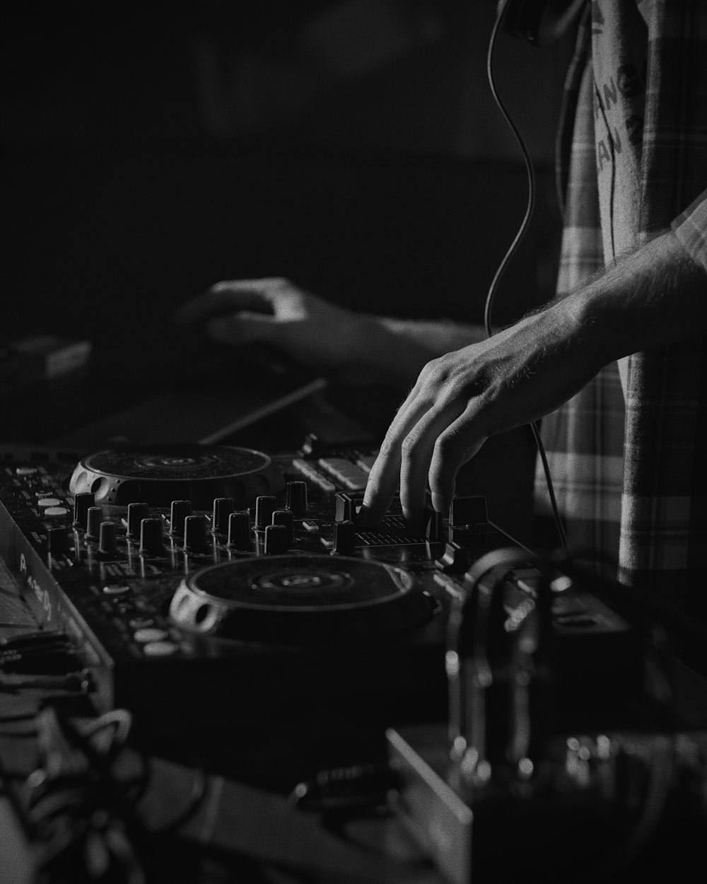 person playing dj mixer in grayscale photography