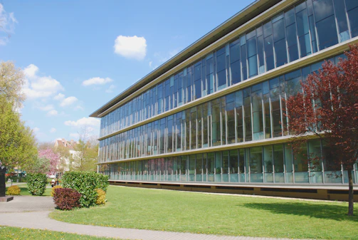 A modern administrative building with glass facades reflecting the surrounding greenery.