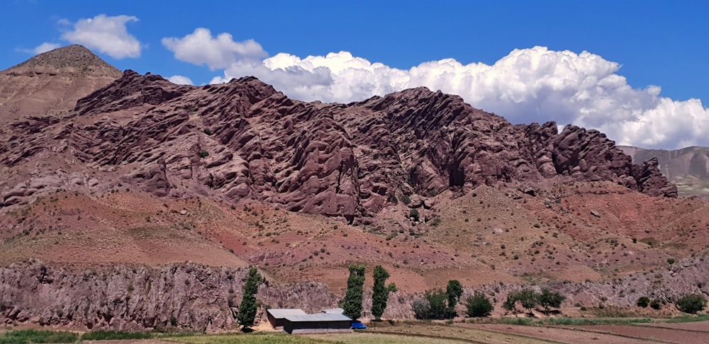 Panchina di legno marrone vicino alla montagna rocciosa marrone sotto il cielo blu durante il giorno
