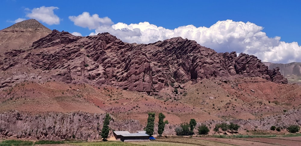 brown wooden bench near brown rocky mountain under blue sky during daytime