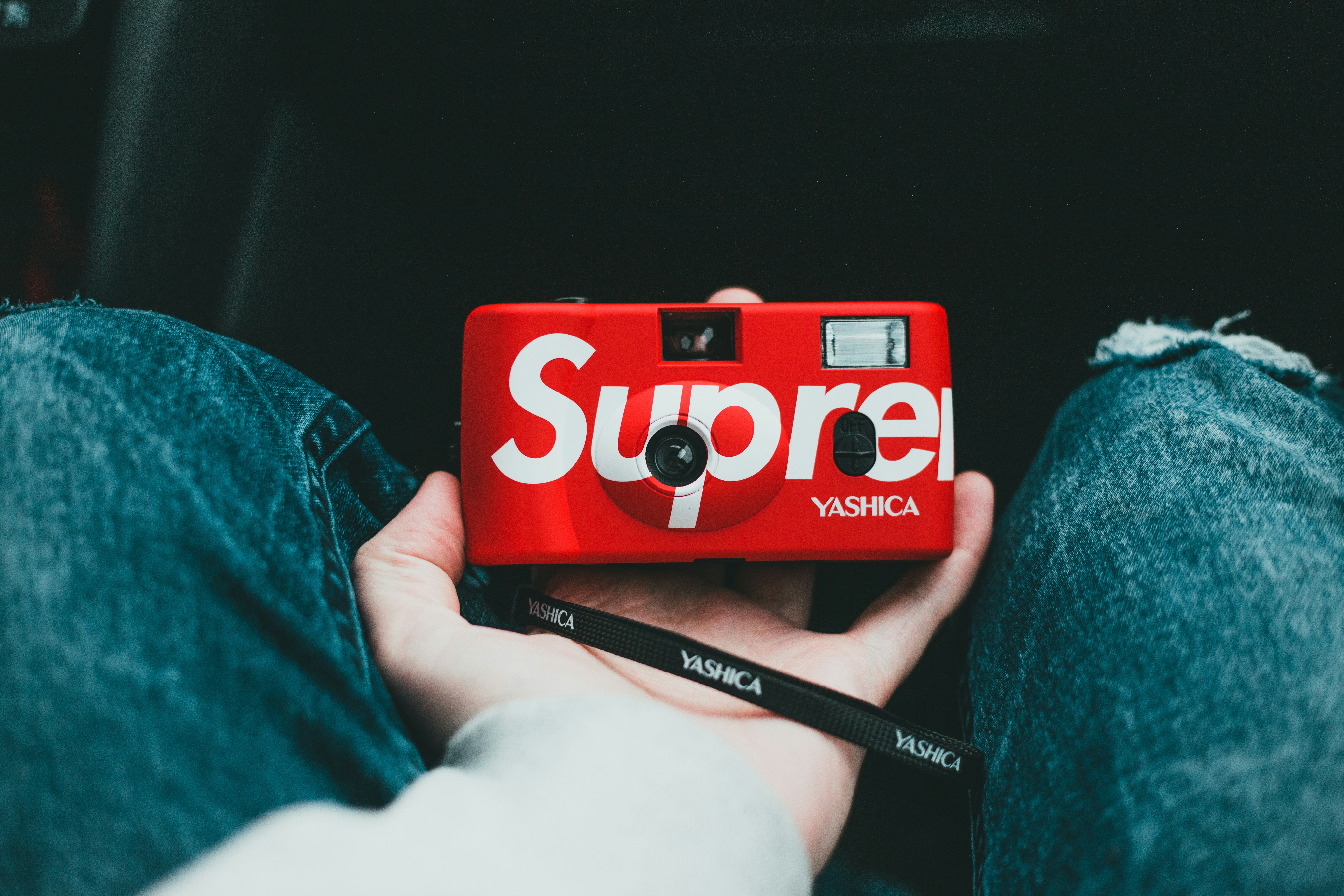 person holding red and white box