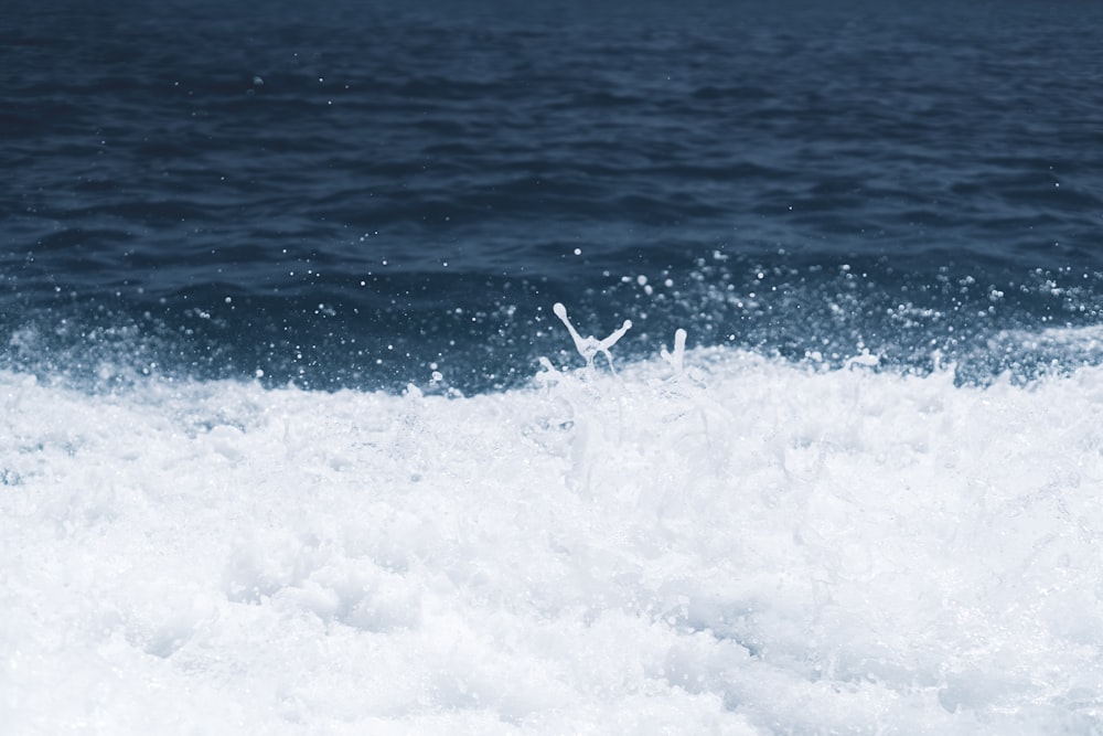 neve bianca sull'acqua blu dell'oceano durante il giorno