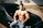 topless man in blue denim jeans sitting on car hood