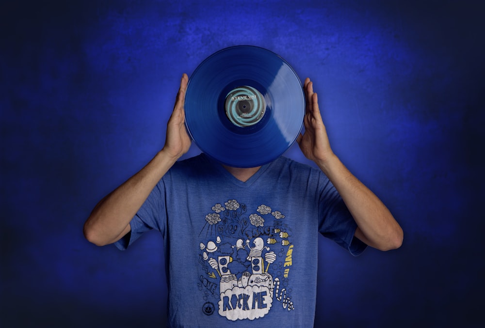 man in blue and white crew neck t-shirt holding blue round disc