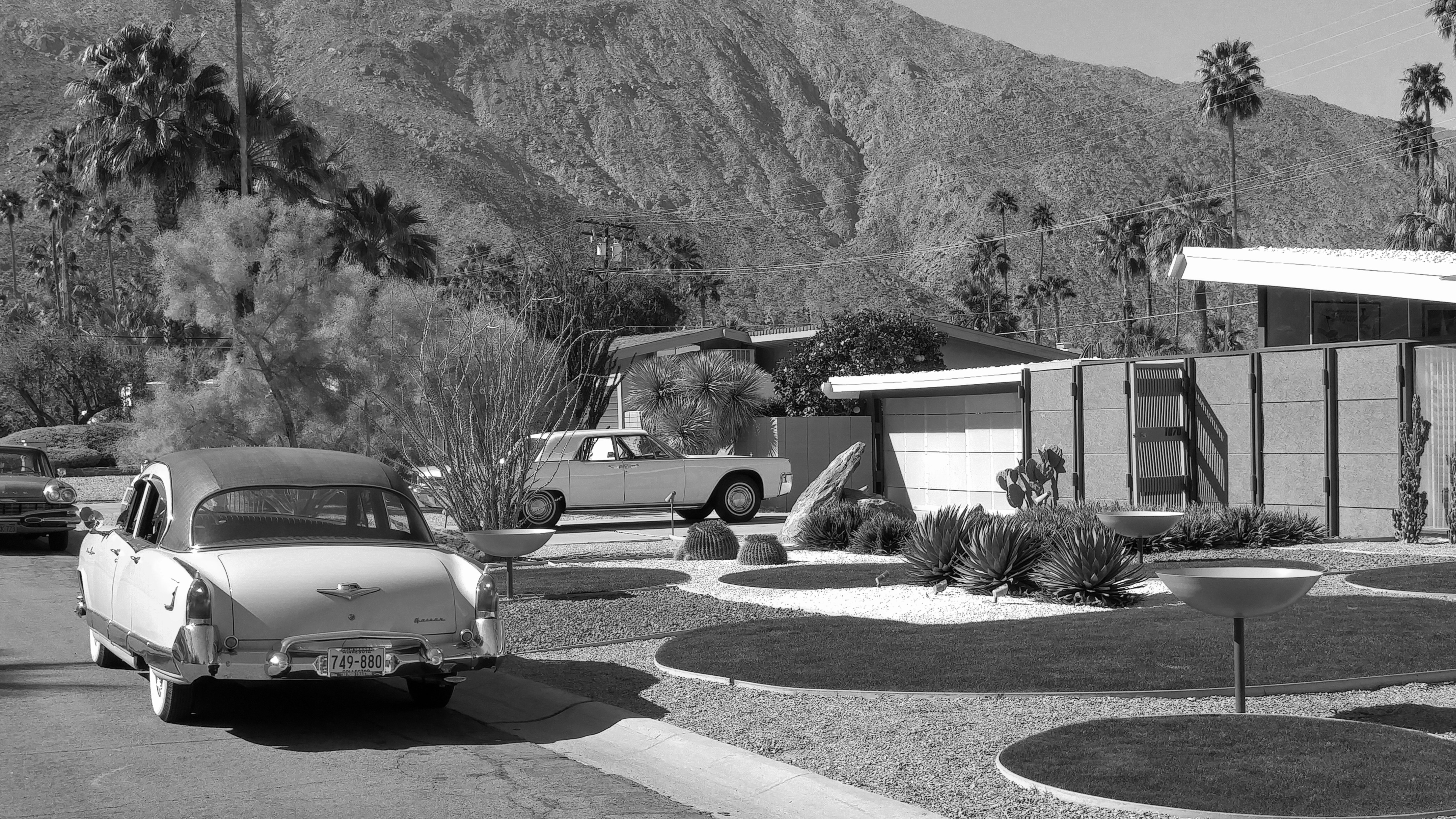 grayscale photo of car parked near house