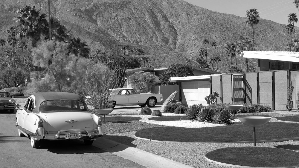 grayscale photo of car parked near house