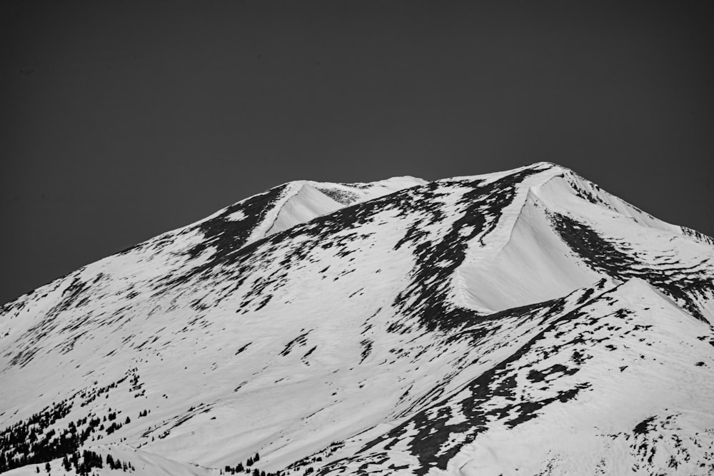 Foto en escala de grises de una montaña cubierta de nieve