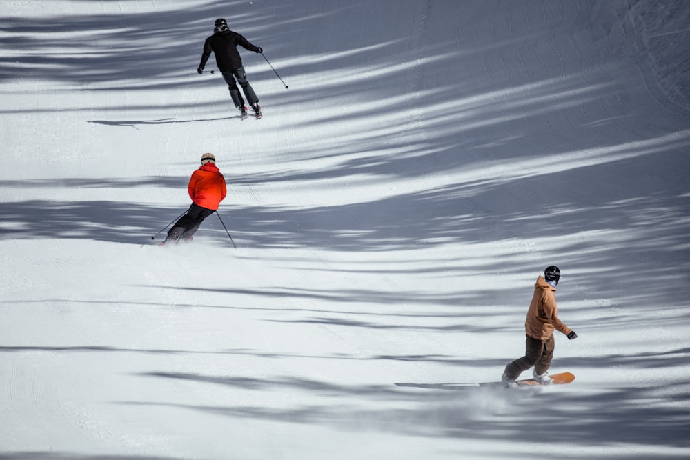 Hombre con chaqueta marrón y pantalones grises sosteniendo bastones de esquí en suelo cubierto de nieve durante el día